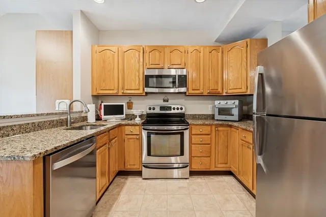 a kitchen with stainless steel appliances granite countertop a refrigerator sink stove microwave and cabinets