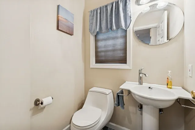 a bathroom with a toilet sink and mirror