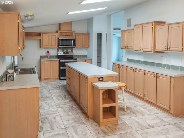 a kitchen that has a lot of cabinets in it and stainless steel appliances