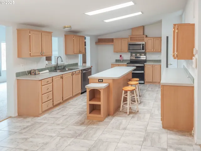 a kitchen with stainless steel appliances granite countertop a stove top oven a sink a counter top space and cabinets