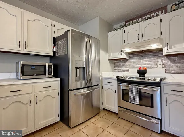 a kitchen with a sink and a stove with wooden floor