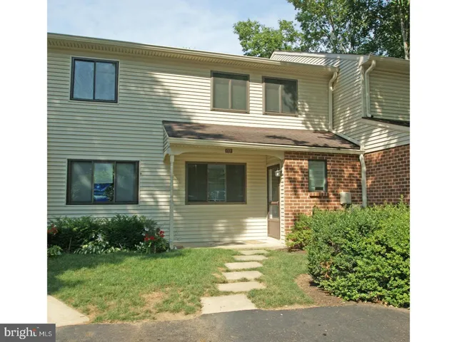 a view of a house with many windows and plants