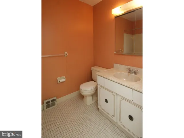 a bathroom with a granite countertop toilet and a sink