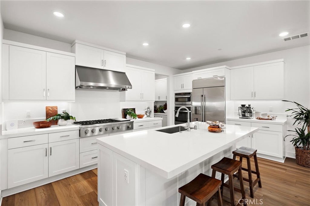 312 Merit Irvine, CA 92618 - Photo 5 of 46 a kitchen that has a lot of white cabinets and stainless steel appliances