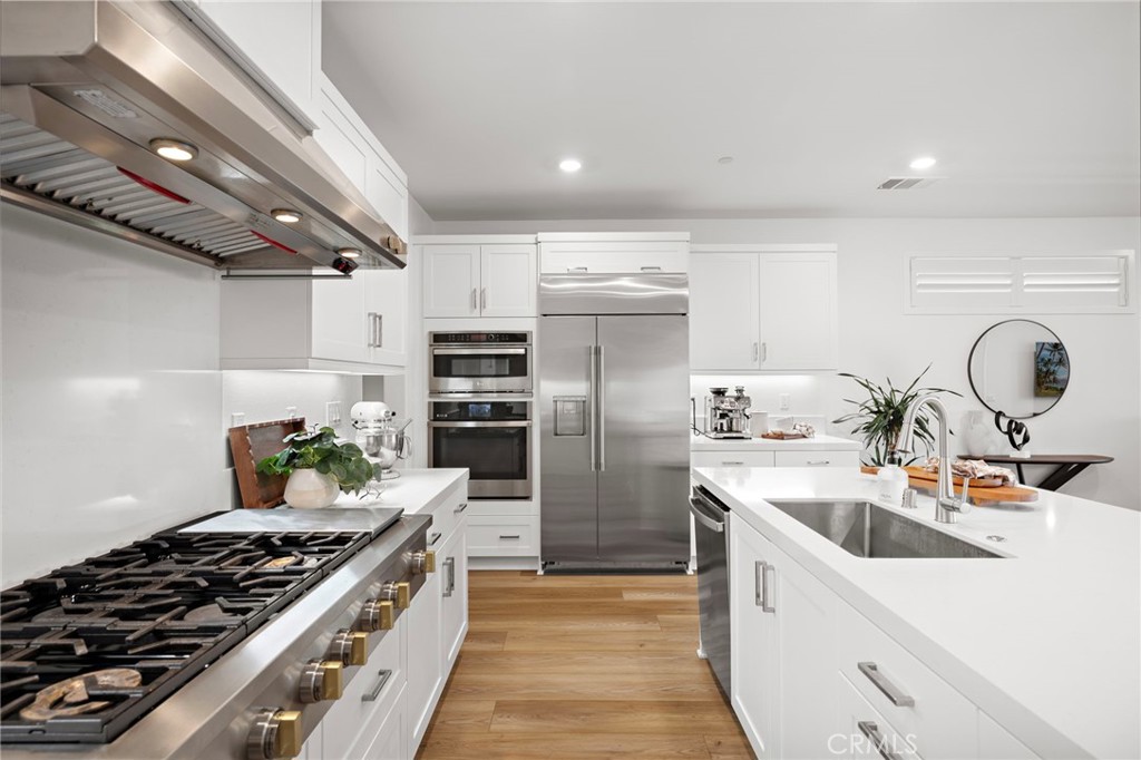 312 Merit Irvine, CA 92618 - Photo 6 of 46 a kitchen with refrigerator a sink and wooden cabinets
