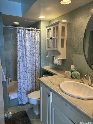 a bathroom with a granite countertop toilet sink and shower