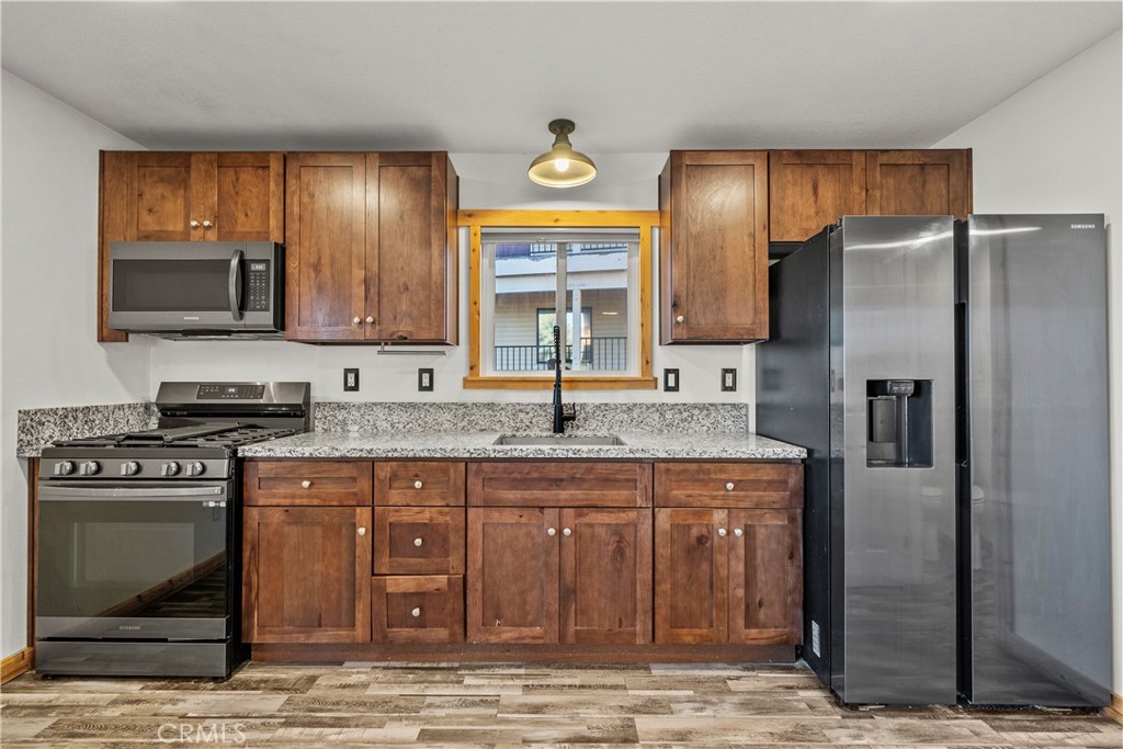 714 Paine Road Big Bear Lake, CA 92315 - Photo 25 of 39 a kitchen with stainless steel appliances granite countertop a stove a sink and a refrigerator