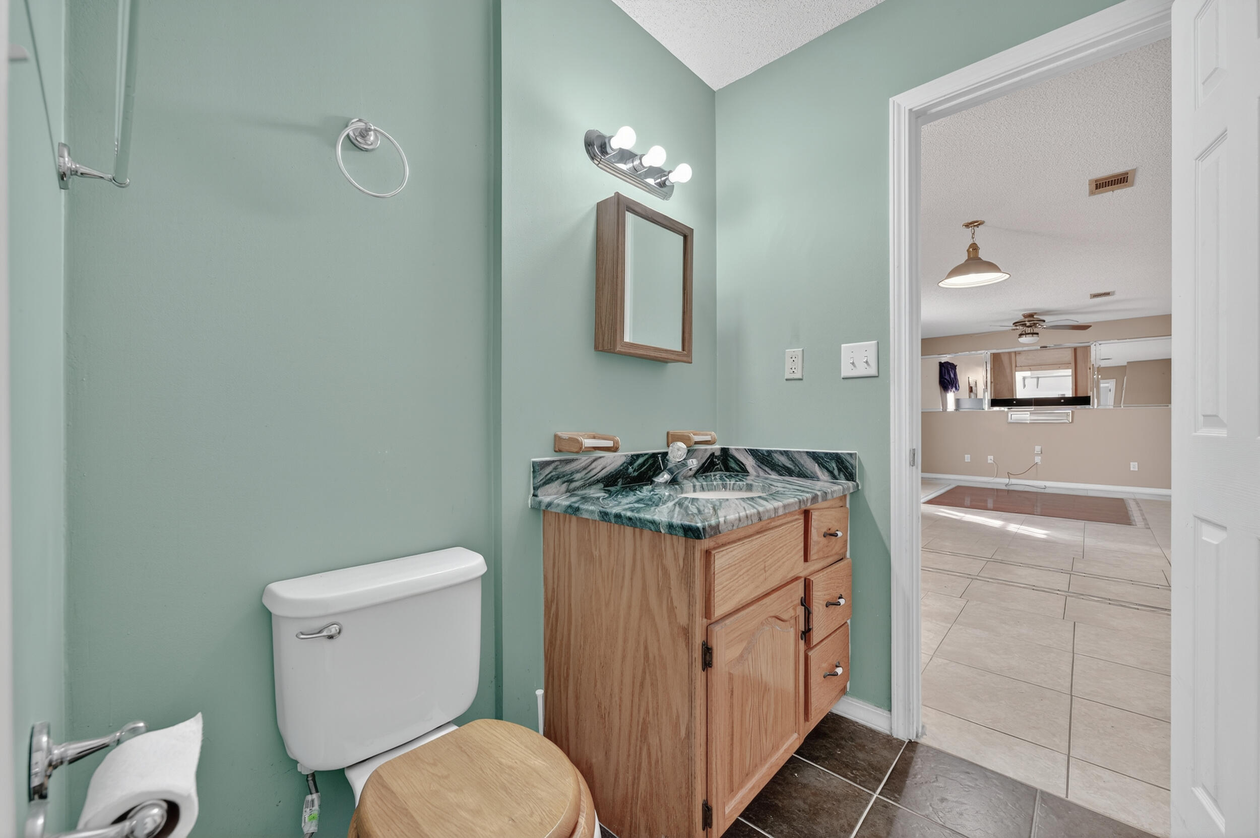 5688 Ridge Avenue Milton, FL 32583 - Photo 15 of 31 a bathroom with a granite countertop toilet sink and mirror