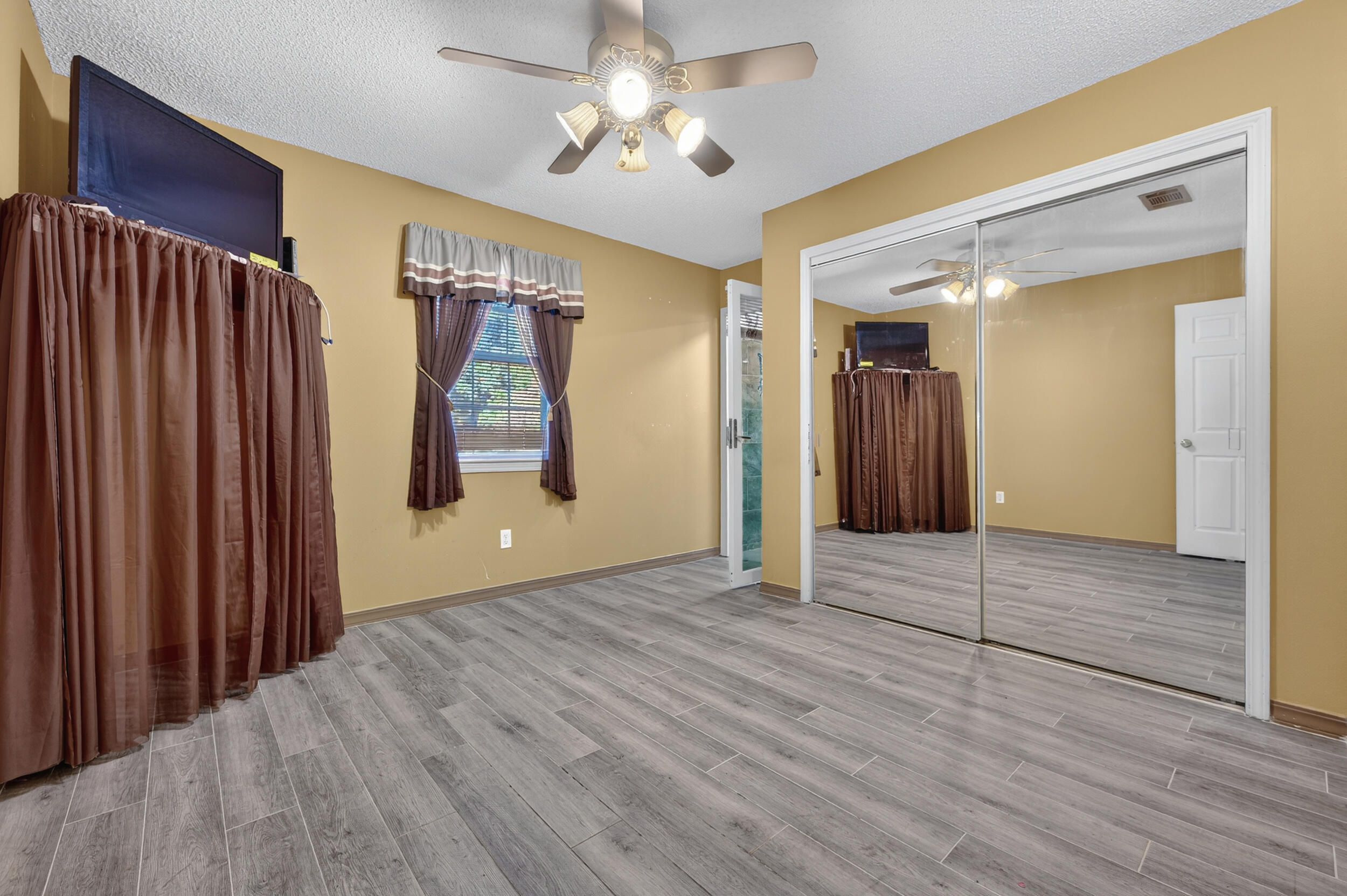 5688 Ridge Avenue Milton, FL 32583 - Photo 9 of 31 a view of an empty room with wooden floor and a ceiling fan