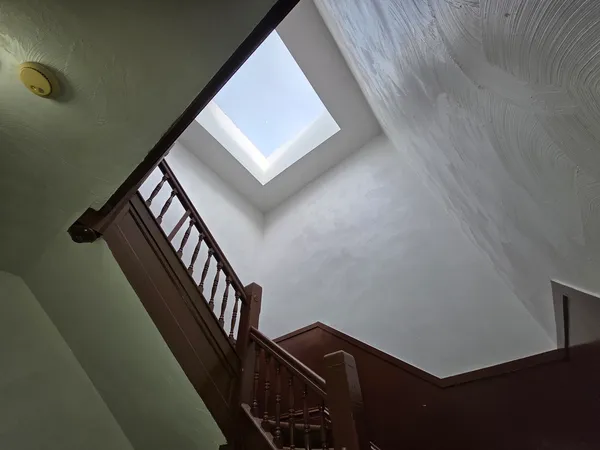 a view of a hallway with wooden floor and a staircase