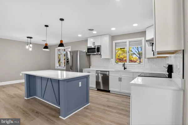 a kitchen with stainless steel appliances kitchen island granite countertop wooden floors and wide window