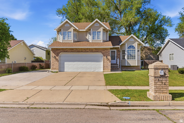 134 West 475 South Ogden, UT 84404 - Photo 1 of 27 Traditional-style house with driveway, roof with shingles, brick siding, and an attached garage