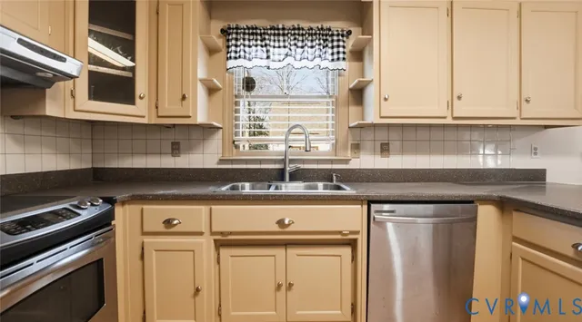 a kitchen with stainless steel appliances granite countertop a sink and cabinets with wooden floor