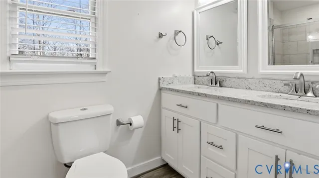 a bathroom with a granite countertop toilet sink and mirror