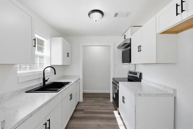 a kitchen with stainless steel appliances granite countertop a sink and a stove top oven