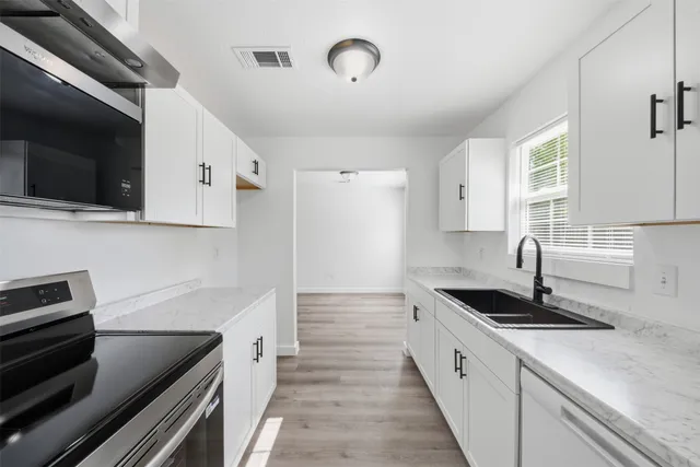 a kitchen with granite countertop a stove and a sink