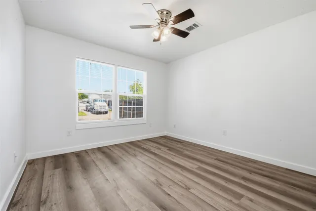 a view of room with hardwood floor and ceiling fan