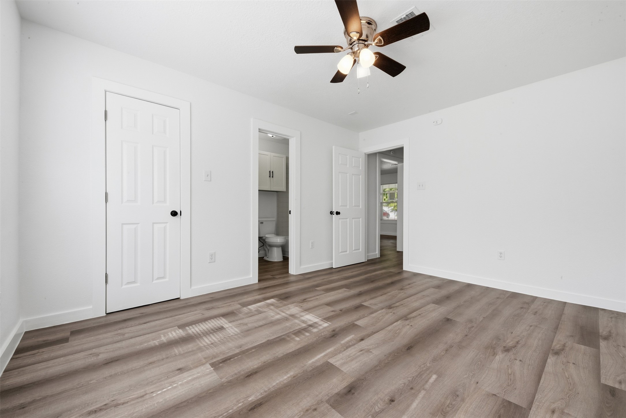 111 Calvin Street Pasadena, TX 77506 - Photo 22 of 40 an empty room with wooden floor ceiling fan and windows