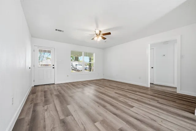 wooden floor in an empty room with a window