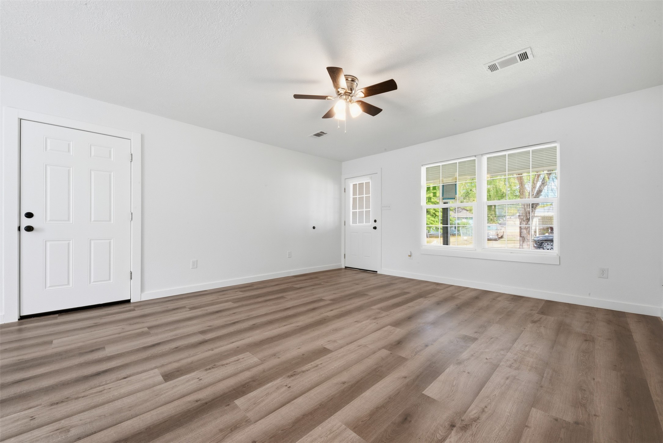 111 Calvin Street Pasadena, TX 77506 - Photo 6 of 40 a view of an empty room with wooden floor and a window
