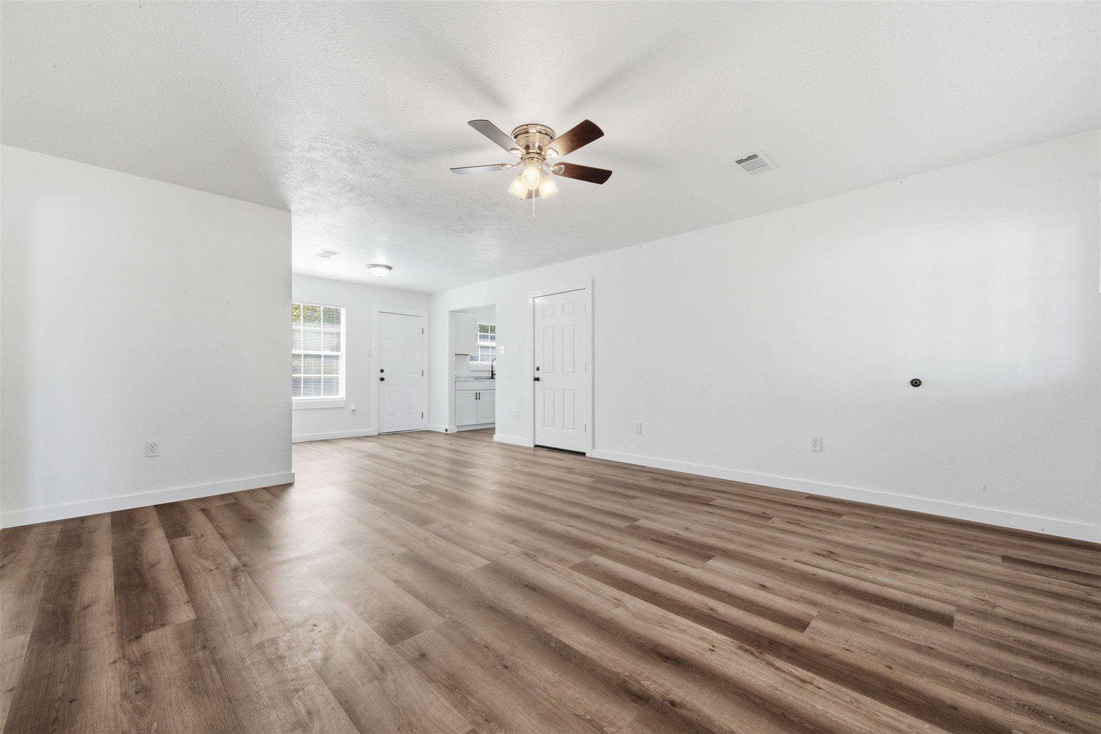 111 Calvin Street Pasadena, TX 77506 - Photo 8 of 40 a view of an empty room with wooden floor and a ceiling fan