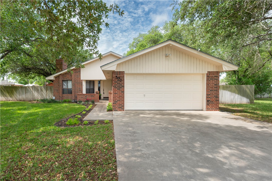 a view of a house with yard and a garage