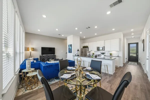 a kitchen with a sink dining table and chairs