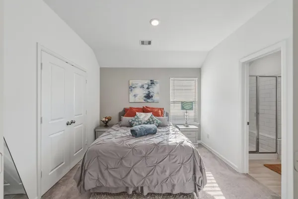 a bedroom with a bed and glass door