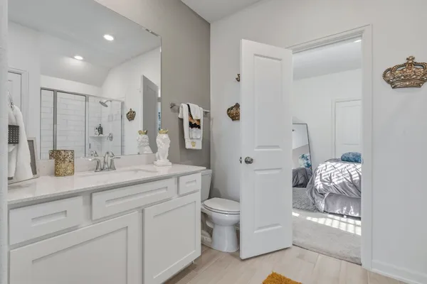 a spacious bathroom with a granite countertop sink a toilet and a mirror