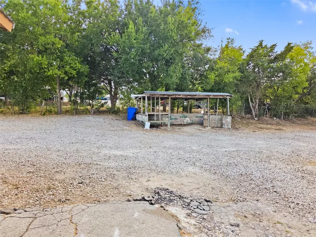 a view of a house with backyard and trees
