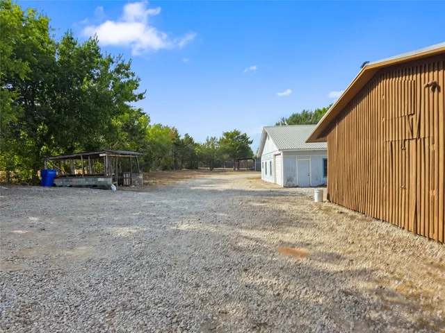 a view of a house with backyard and trees