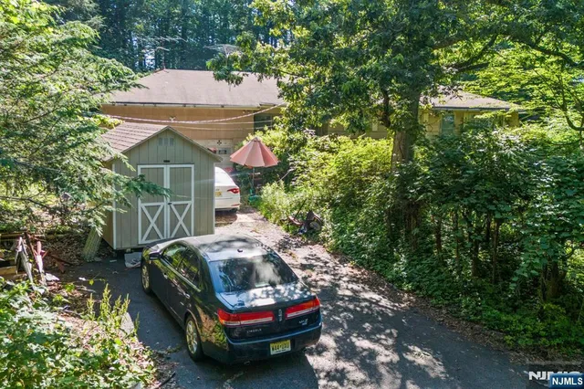 a backyard of a house with table and chairs under an umbrella