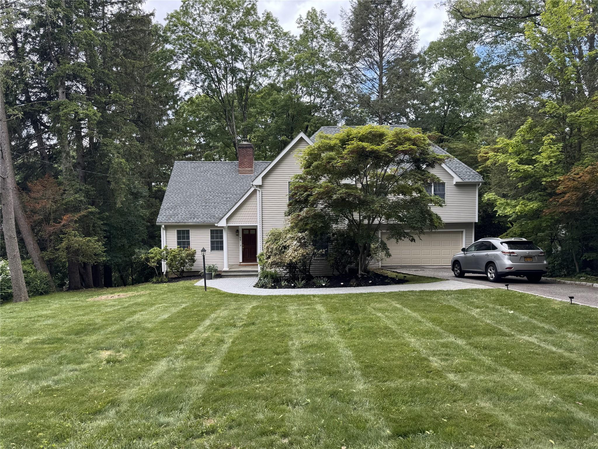 a view of a house with a yard and sitting area