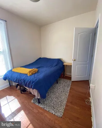 a room with a bed and wooden floor