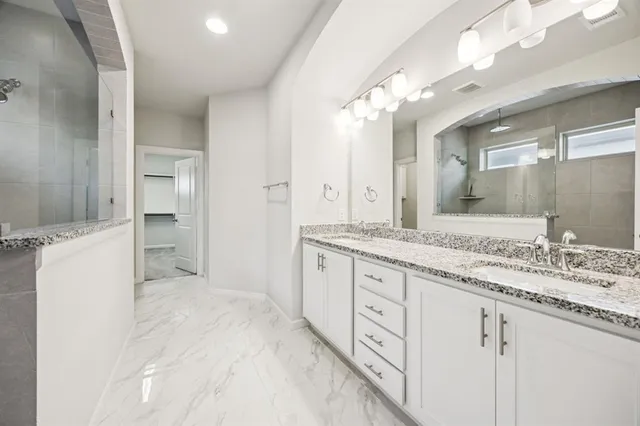 a bathroom with a granite countertop sink mirror and vanity
