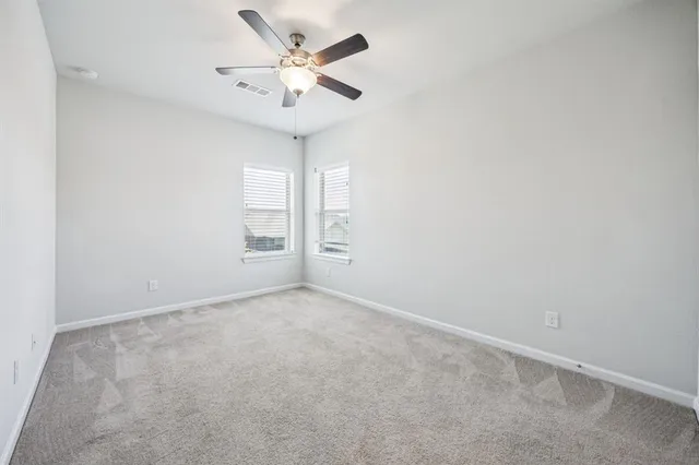 an empty room with a window and a ceiling fan
