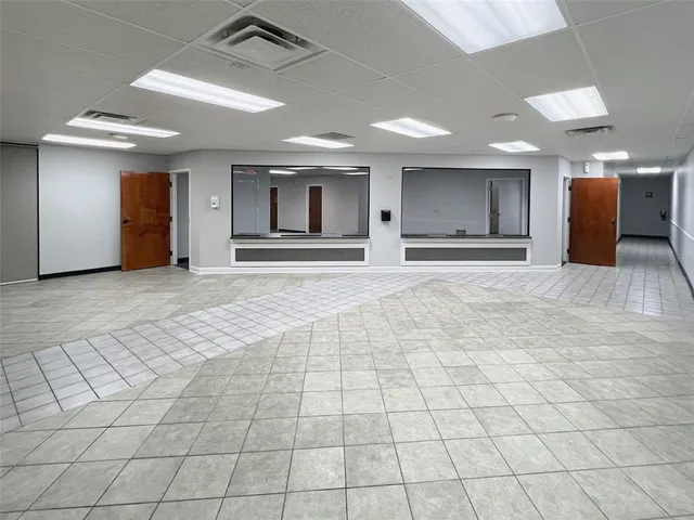an empty room with kitchen view and a window