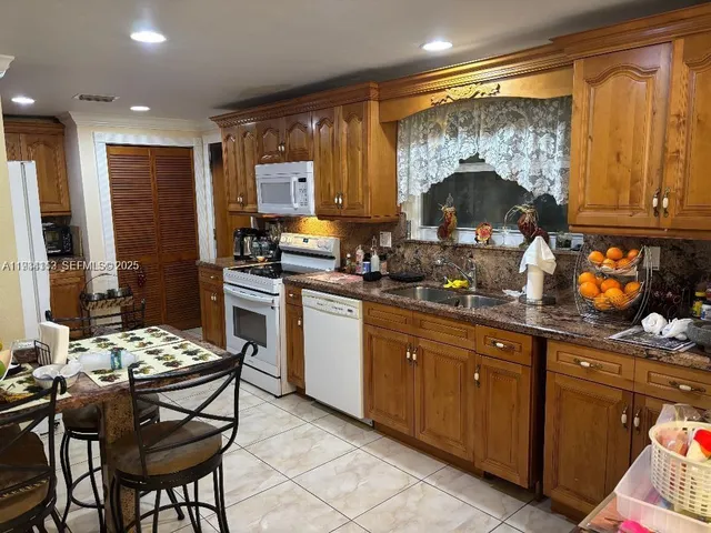 a kitchen with a table chairs stove and cabinets