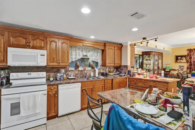 a kitchen with stainless steel appliances granite countertop a sink and cabinets