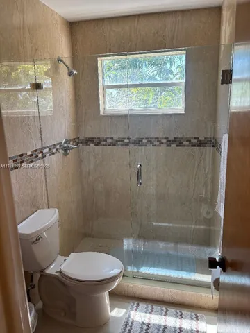a bathroom with a toilet and a shower