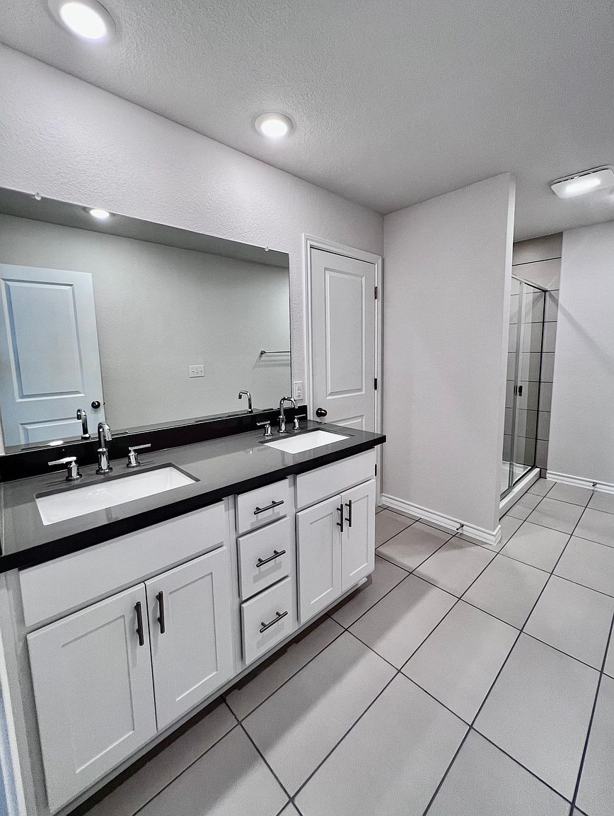 4701 Lavender Field Path, Unit 186 Austin, TX 78723 - Photo 18 of 29 a spacious bathroom with a granite countertop sink and a mirror