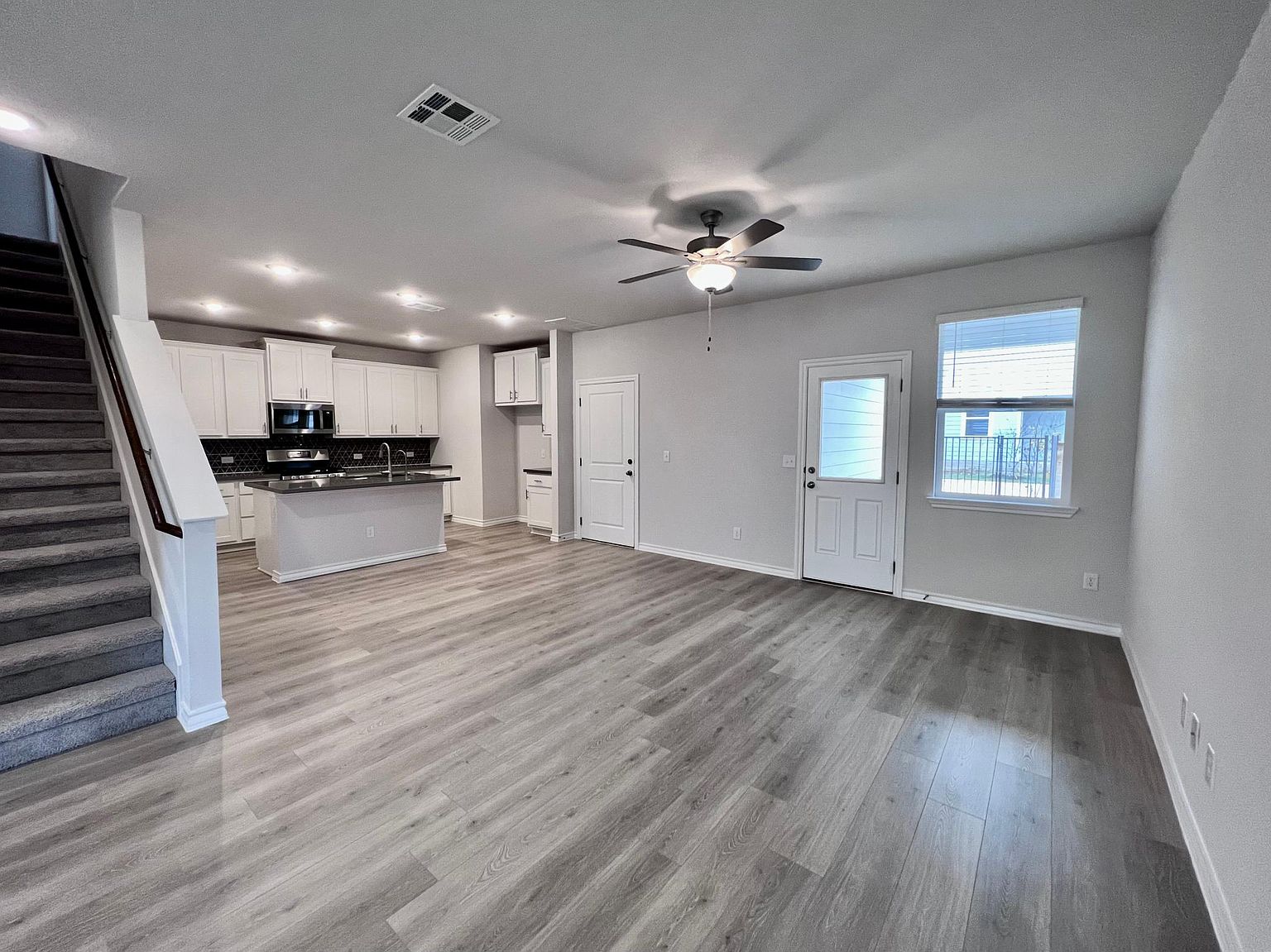 4701 Lavender Field Path, Unit 186 Austin, TX 78723 - Photo 6 of 29 a view of a kitchen with wooden floor and a ceiling fan