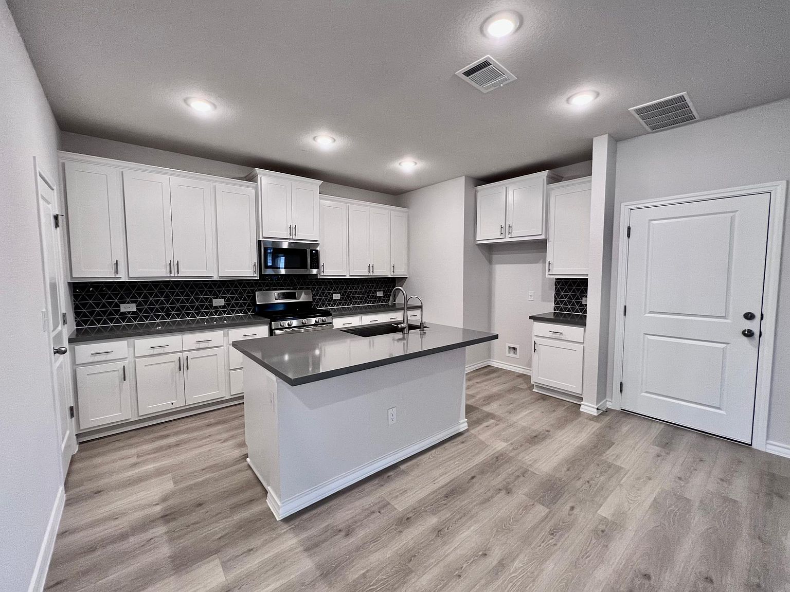 4701 Lavender Field Path, Unit 186 Austin, TX 78723 - Photo 9 of 29 a kitchen with granite countertop white cabinets and white appliances