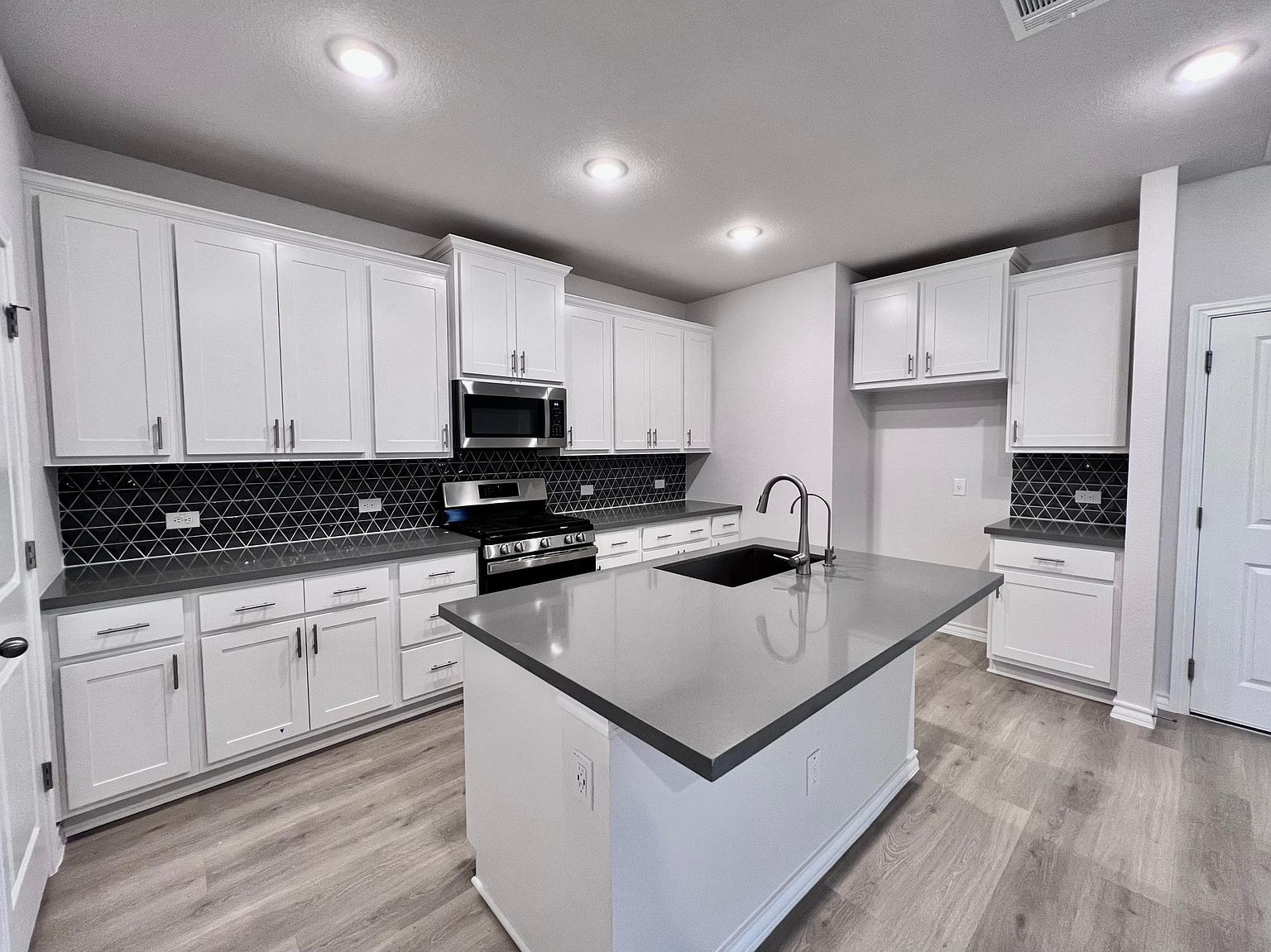 4701 Lavender Field Path, Unit 186 Austin, TX 78723 - Photo 10 of 29 a kitchen with kitchen island white cabinets appliances and a sink