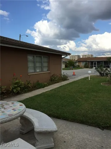 a backyard of a house with table and chairs plants