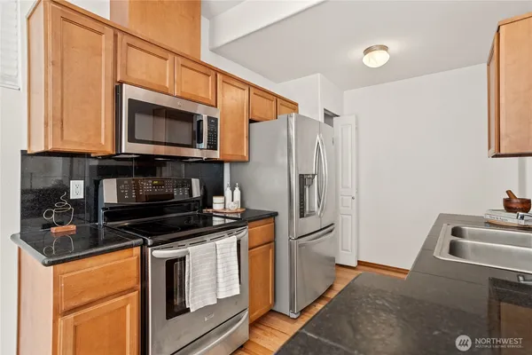 a kitchen with stainless steel appliances a stove microwave and refrigerator