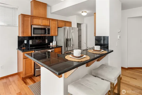 a kitchen with a sink a microwave and chairs