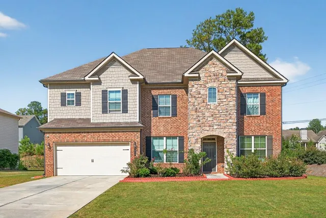 a front view of a house with a yard and garage