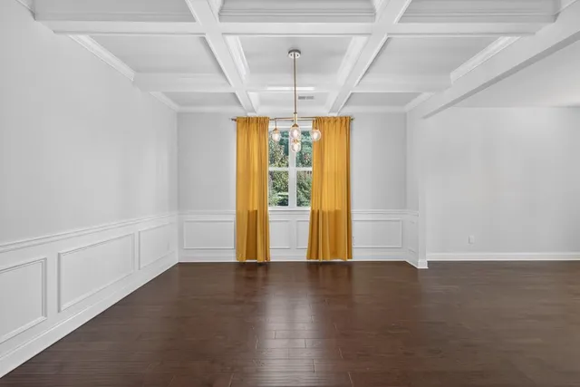 a large white kitchen with kitchen island white cabinets and wooden floor