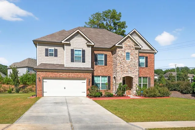 a front view of a house with a yard and garage